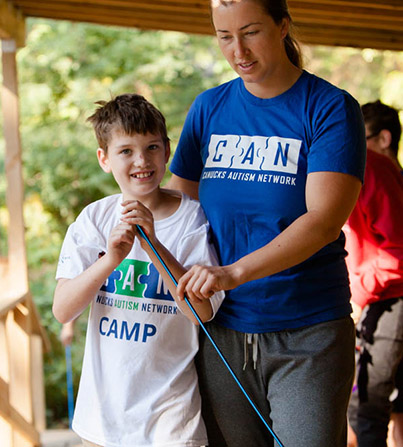 A young boy outside hanging out with a staff member of CAN.