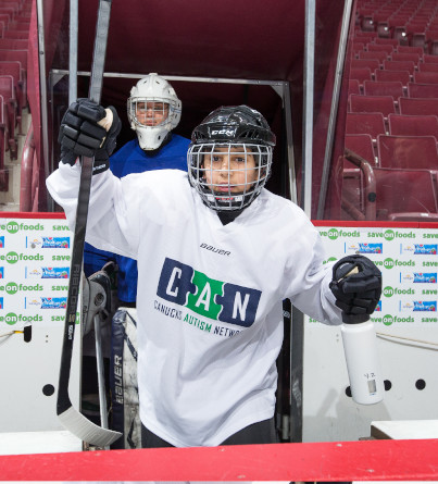 Canucks Autism Network hockey team members entering ice rink.