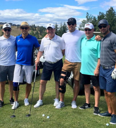 Six golfers pose for a photo on the golf course.