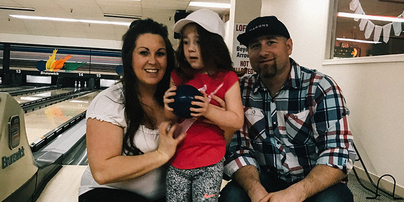 A family enjoys a day out bowling.